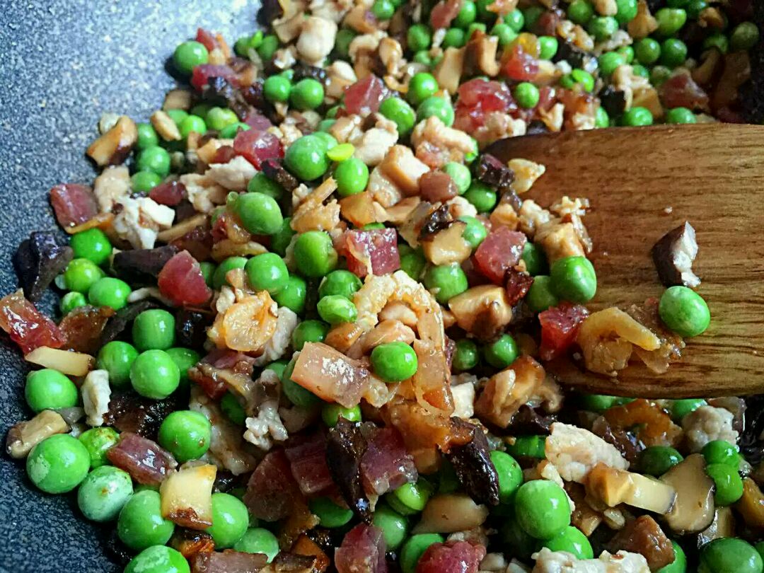 选麦豆粒(学名:豌豆)和糯米,加入熏火腿心或腊肉