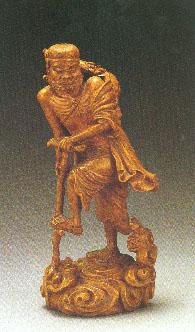  p>黄杨木雕铁拐李像,面目丑陋,袒腹跛足,蓬头束箍,卷须巨眼,手拄铁杖