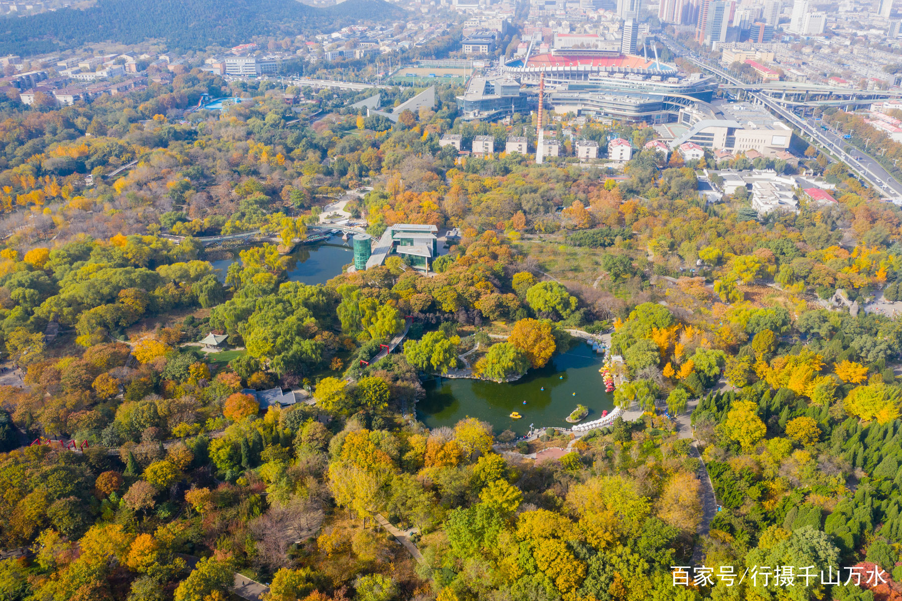 航拍深秋时节的济南泉城公园，各种树木五彩斑斓，满园秋色美如画_百科TA说