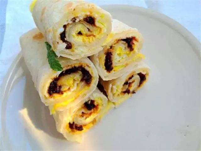 烙饼卷鸡蛋将鸡蛋煎熟,用摊好的鸡蛋放在大饼上,卷起来就可以吃的食物