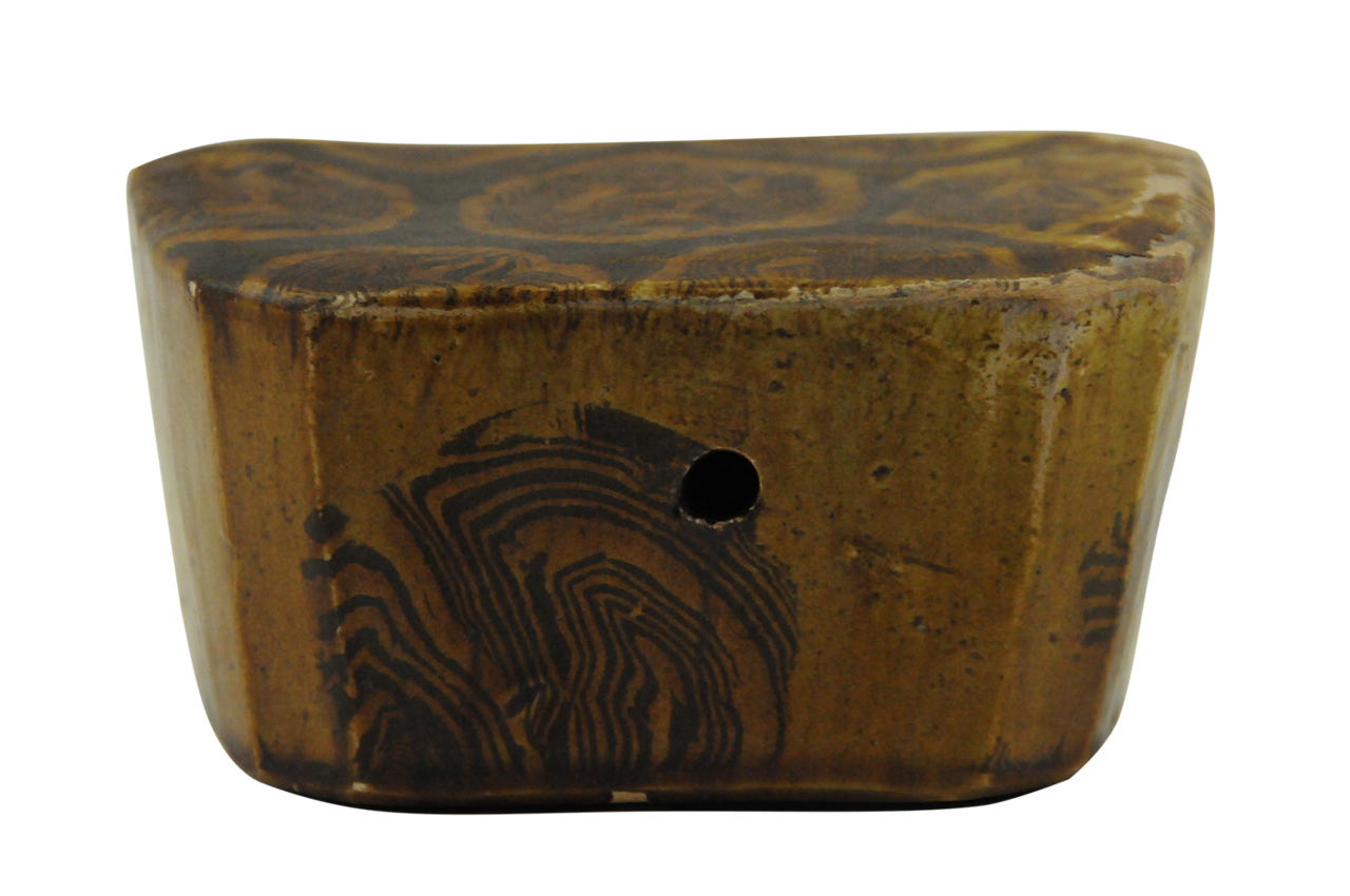  p>唐胶胎花朵纹黄釉脉枕为唐代文物.高6.1厘米,长12.1厘米,宽18.