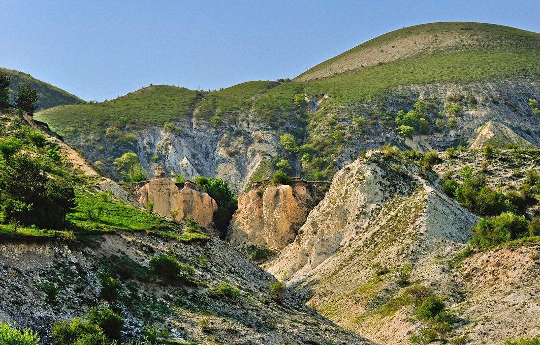 形成一种缓缓倾斜的平整基岩面,土覆薄层松散堆积物,称为山麓剥蚀面