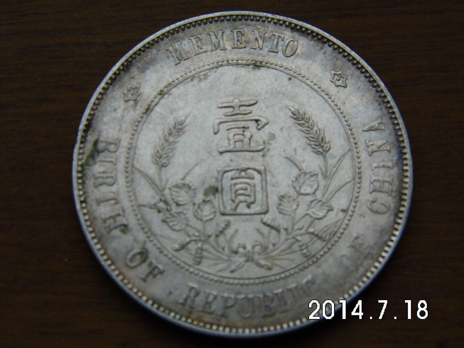 即中华民国孙像开国纪念币银元,正面中央为孙中山侧面肖像,边缘内上镌