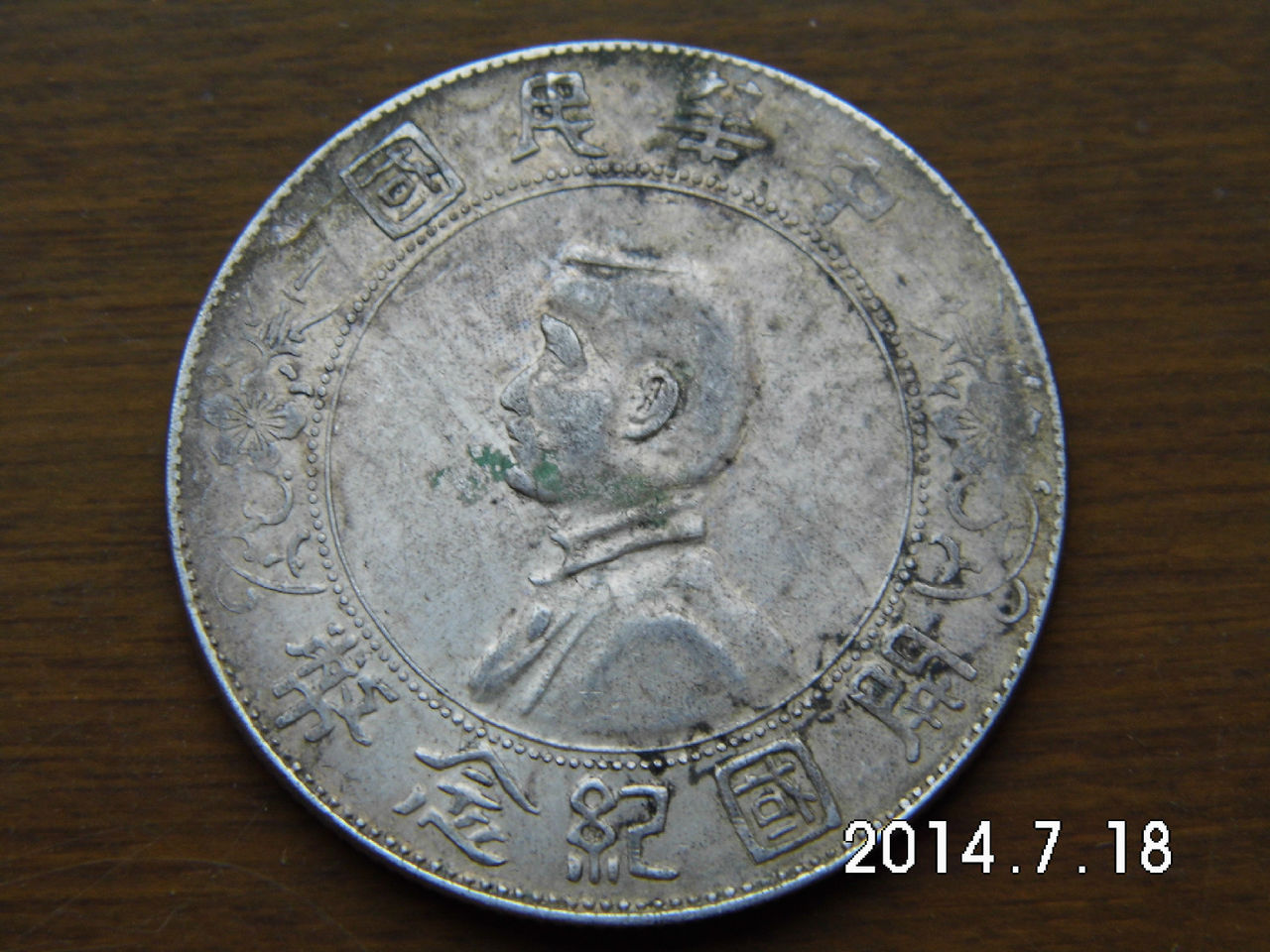 即中华民国孙像开国纪念币银元,正面中央为孙中山侧面肖像,边缘内上镌