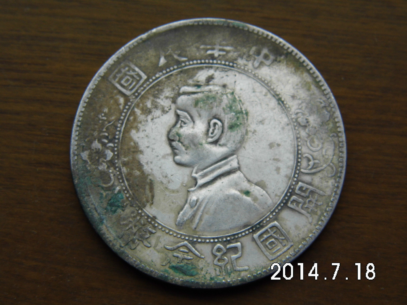 即中华民国孙像开国纪念币银元,正面中央为孙中山侧面肖像,边缘内上镌