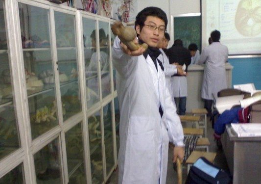 几名身着白大褂,学生模样的男子,在一间陈列着骨骼和器官标本的房间里